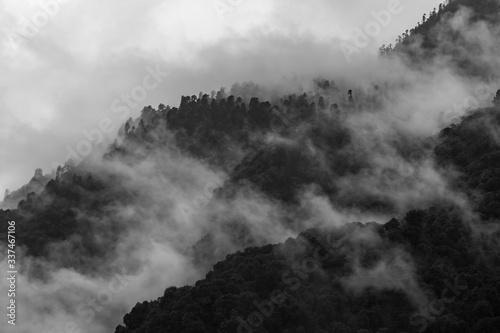 a beautiful mountain view with fog and clouds