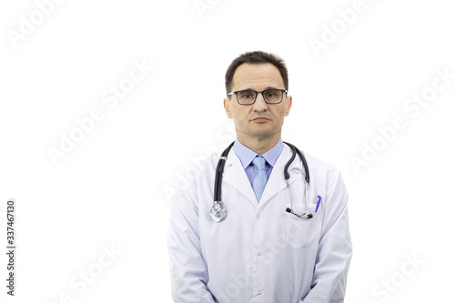 The therapist with glasses in a white coat with a stethoscope stands on a white background and looks at the camera. Medical worker. Serious look. Portrait of a doctor. Copyspace