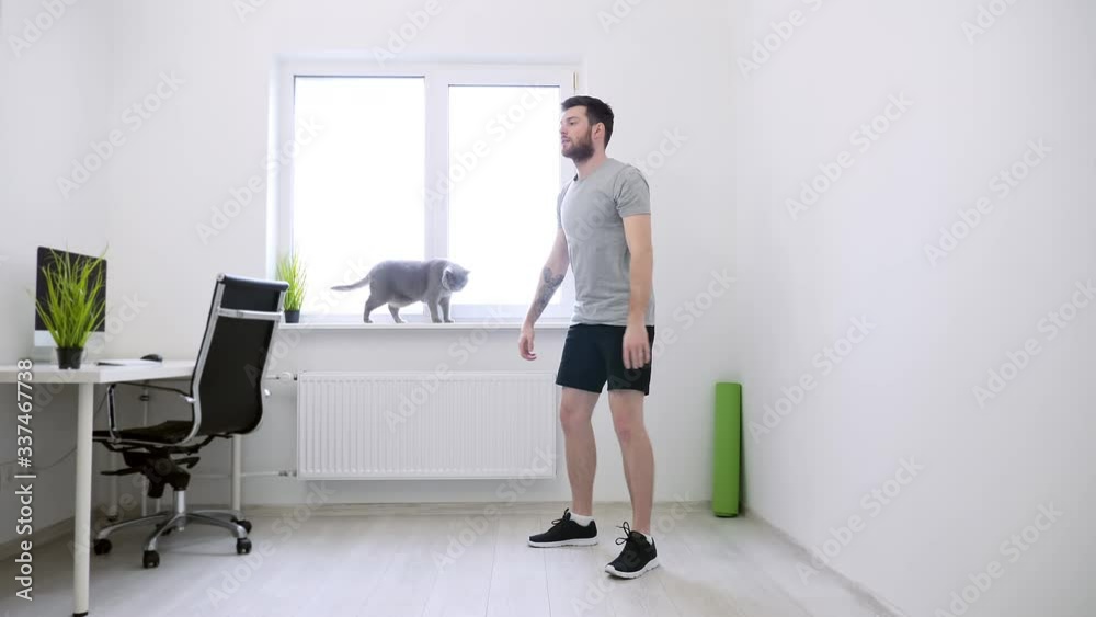 Man Doing Squats at Home. Man Working Out at Home. Home Sport, Healthy Life, Quarantine Concept. Sports at Home Man Doing Squats at Home. Man Working Out at Home. Home Sport, Healthy Life, Quarantine Concept. Sports at Home