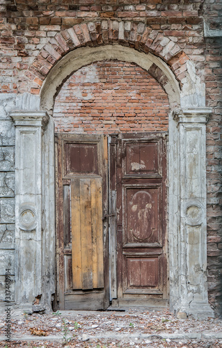 Old wooden door in a destroyed brick building