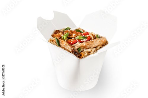 Tasty chicken teriyaki wok noodle garnished with spring fresh spring onion, sesame seed and red bell pepper on top. Perfect for delivery takeaway. Plain white food container for branding.