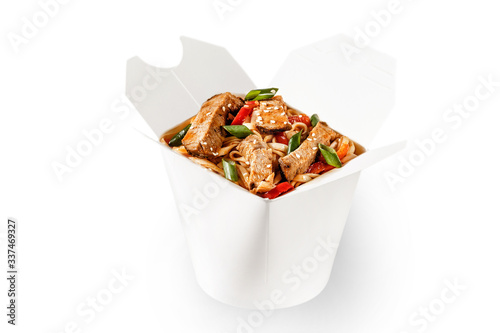 Delicious beef teriyaki wok noodles with fresh spring onion, sesame seeds and red bell pepper. Perfect for delivery and branding space for text available. Plain white food container delivery takeaway.