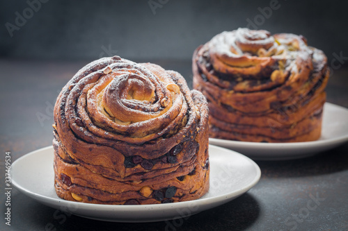 Homemade cruffin cake, made with yeast. Filled with butter, chiocolate, nuts and raisins. Modern food. Dark background. photo