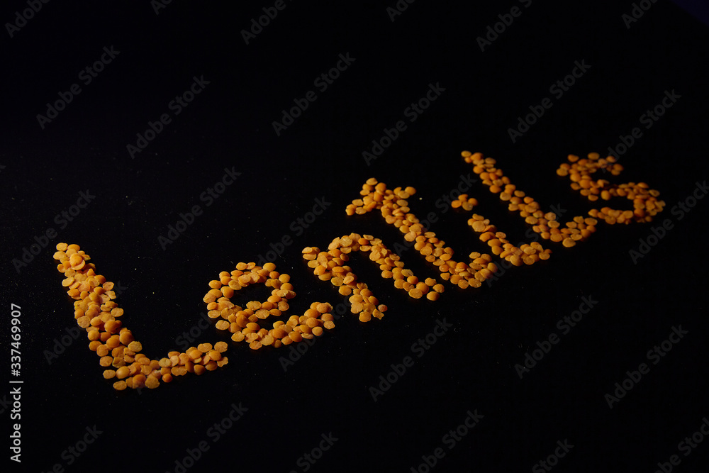 Red lentils on a black background. the word Red lentils on a black background. the word