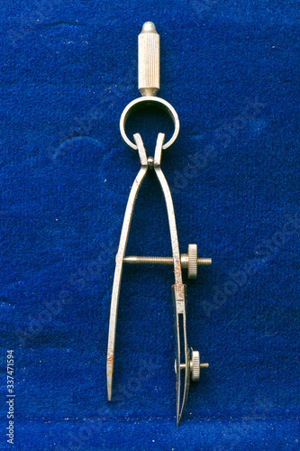 Antique drafting deviders on blue felt