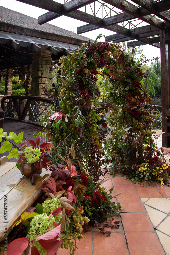 grapevine wedding arch with interwoven roses, carnations, celosia, amaranth, hops