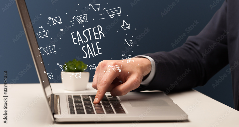 Businessman working on laptop with EASTER SALE inscription, online shopping concept Businessman working on laptop with EASTER SALE inscription, online shopping concept