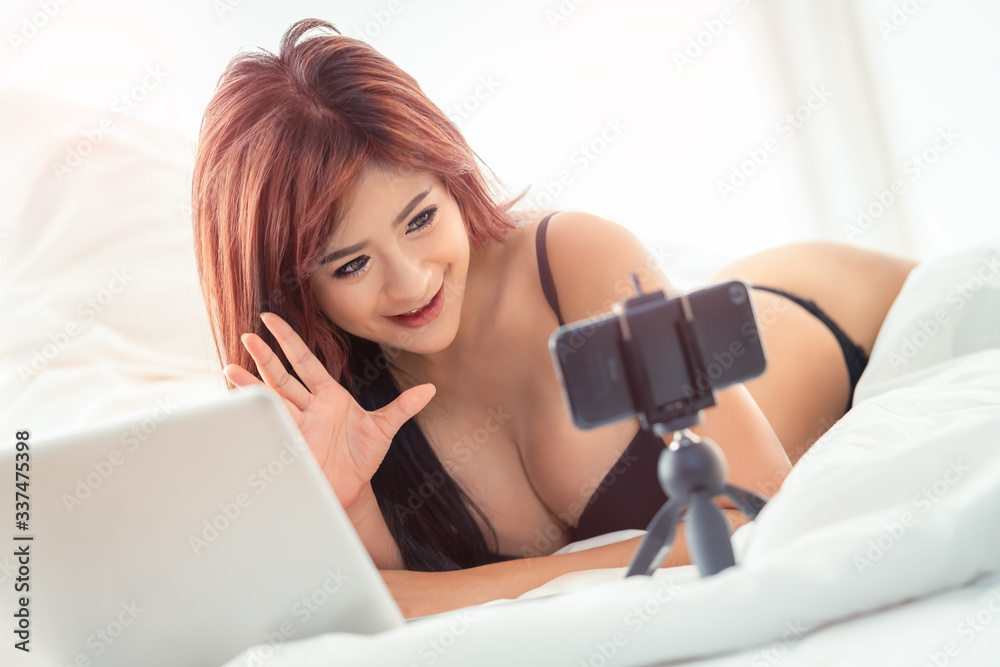 Woman with underwear using phone to boardcast seductive webcam live show  online Stock Photo | Adobe Stock