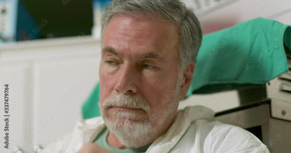 An exhausted doctor overwhelmed and overworked during the COVID19 outbreak removes his mask and sits on the floor at the end of his long shift. An exhausted doctor overwhelmed and overworked during the COVID19 outbreak removes his mask and sits on the floor at the end of his long shift.