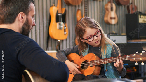 Tablou canvas Dad teaching guitar and ukulele to his daughter