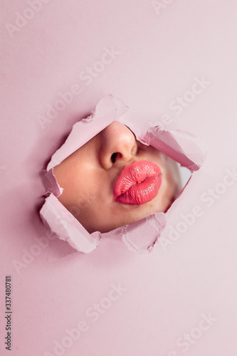 Canvas Print Girl Pouting Lips Through Hole In Pink Paper. Makeup, Beauty
