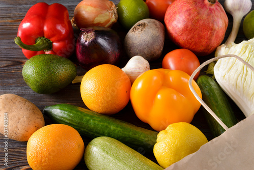 fresh vegetables and fruits on a wooden background  pepper  orange  onion  cucumber  avocado  zucchini  pomegranate  lemon  garlic  potatoes  tomato   lettuce   beet