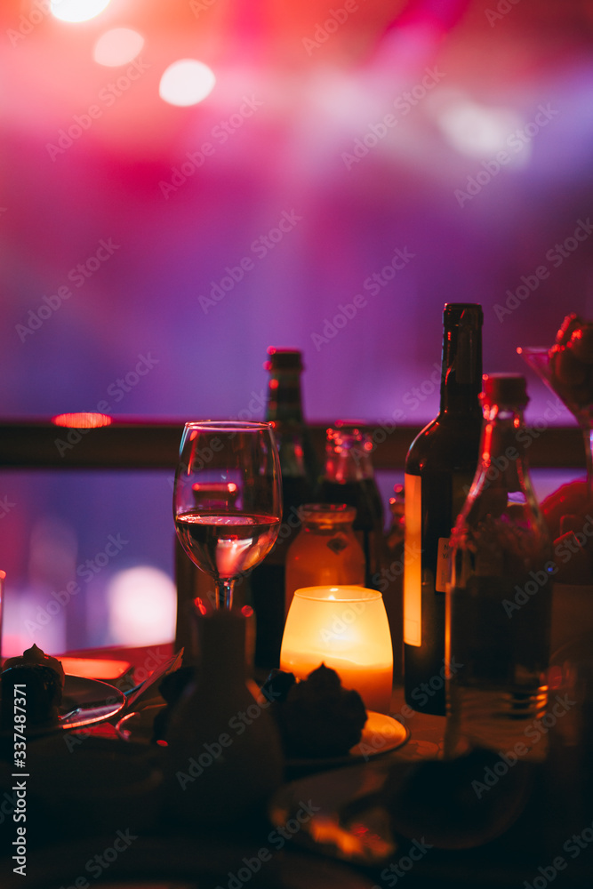 Romantic night in restaurant with wine glass and different types of alcohol drinks