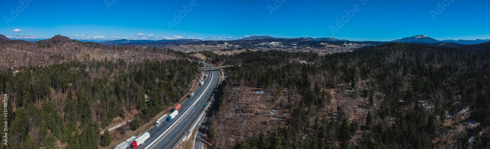 Traffic jam on the motorway or highway. Aerial drone photo of trucks or lorries stuck in a traffic jam over the country. Long queue of semi trailers on a motorway