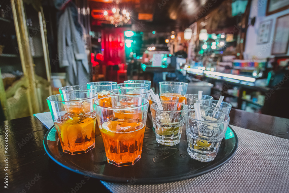 Appetizer drinks and shots waiting on a serving board in a bar waiting for first guests at a pary. Party atmosphere and some drinks in the foreground Appetizer drinks and shots waiting on a serving board in a bar waiting for first guests at a pary. Party atmosphere and some drinks in the foreground