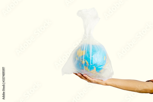 Human hand holding globe in plastic bag in studio