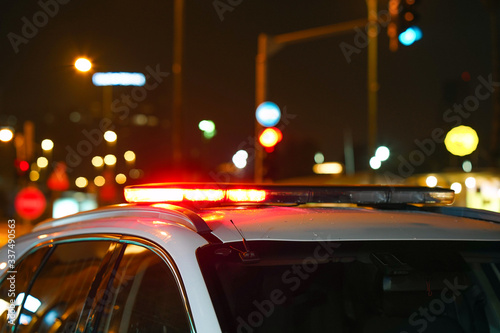 Closeup of red lights on top of a police vehicle at night. Selective focus, blur. photo