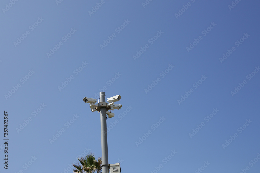 several surveillance cameras on a pillar against a blue sky. The concept of security and tracking. several surveillance cameras on a pillar against a blue sky. The concept of security and tracking.
