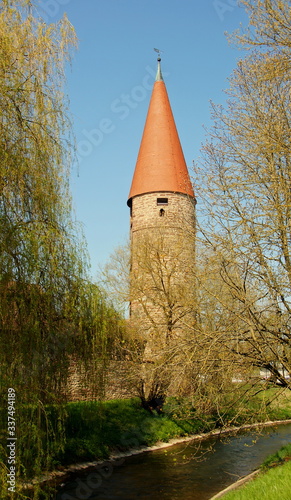 alter Turm an Stadtmauer in Weil der Stadt mit Fluss Würm im Vordergrund an sonnigem Frühlingstag