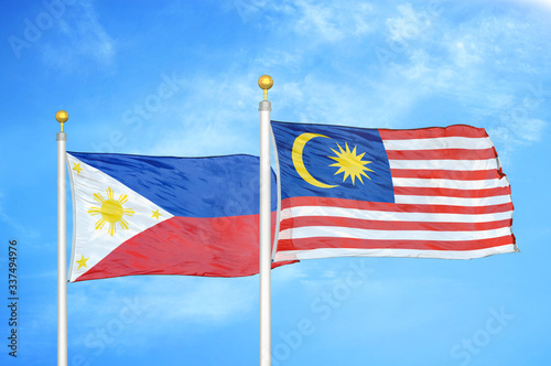 Philippines and Malaysia two flags on flagpoles and blue cloudy sky