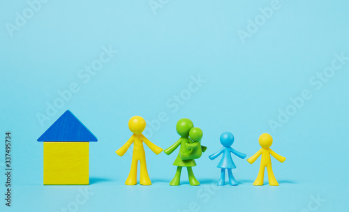 Faceless family on blue background. Stay at home concept. Multi-colored figures of people near the house from childrens mosaic