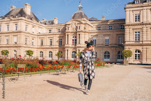 Happy girl in a mikimaus hat in the Luxembourg garden and the Palace in Paris. photo