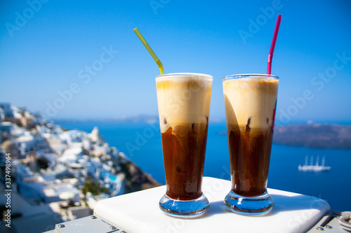 Coffee espresso freddo with a wide sea of caldera in greek cafe. Greece, Santorini island in Cyclades.