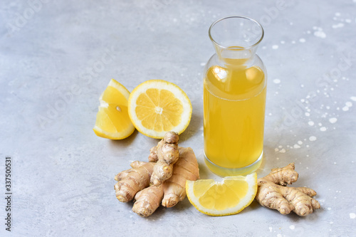 Ginger-lemon drink in a bottle, ingredients of ginger cocktail or tea: ginger root, lemon. Ginger Ale - Homemade lemon and ginger organic probiotic drink or Kombucha, copy space. selective focus