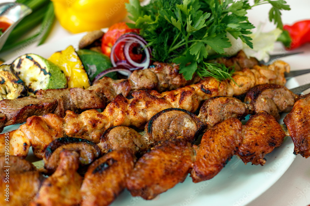 assorted of kebabs with grilled vegetables, pickled onions, herbs and spicy sauce assorted of kebabs with grilled vegetables, pickled onions, herbs and spicy sauce