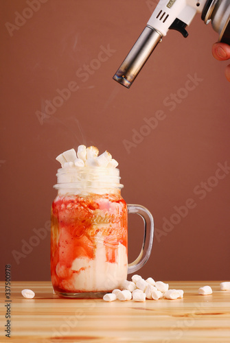 Konstfotografi strauberry milkshake decoration with marshmallow and gas burner with fire