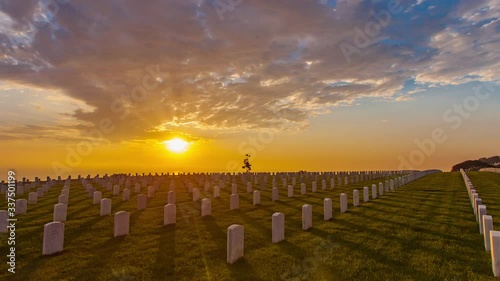 Hyperlapse or time lapse in motion  of the Fort Rosecrans National Cemetery,  military cemetery in the city of San Diego, California, during beautiful cinematic sunset with many rows of graves. photo