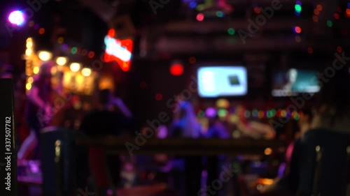 Blurred Background Backdrop Bar Pub Patio At Night With People Singing Dancing photo