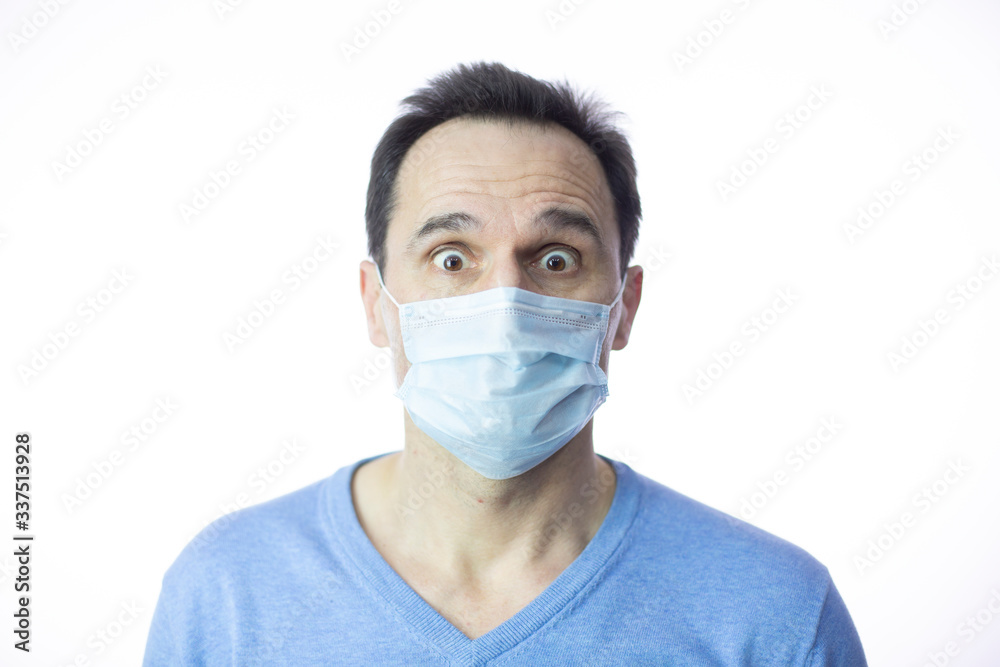 scared in medical mask looks in camera. Scared man in fear of coronavirus stands in protective medical mask against viruses and infections isolated studio. Coronavirus 2019-ncov covid-19 concept. scared in medical mask looks in camera. Scared man in fear of coronavirus stands in protective medical mask against viruses and infections isolated studio. Coronavirus 2019-ncov covid-19 concept.