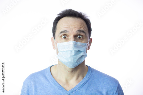 scared in medical mask looks in camera. Scared man in fear of coronavirus stands in protective medical mask against viruses and infections isolated studio. Coronavirus 2019-ncov covid-19 concept. © Model Republic