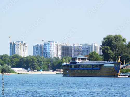 A floating restaurant on Dnipro river against the backdrop of buildings construction in Kyiv  Ukraine.