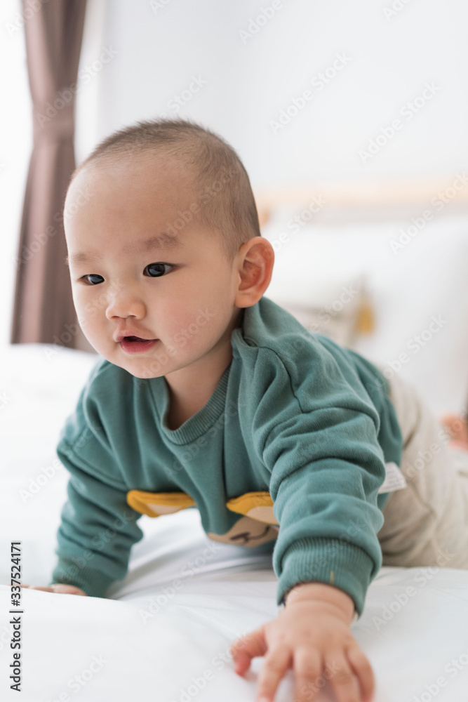 Asian infants crawling and playing on bed Asian infants crawling and playing on bed