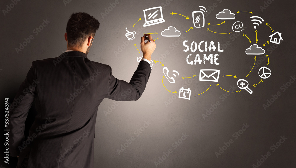 businessman drawing social media icons with SOCIAL GAME inscription, new media concept businessman drawing social media icons with SOCIAL GAME inscription, new media concept