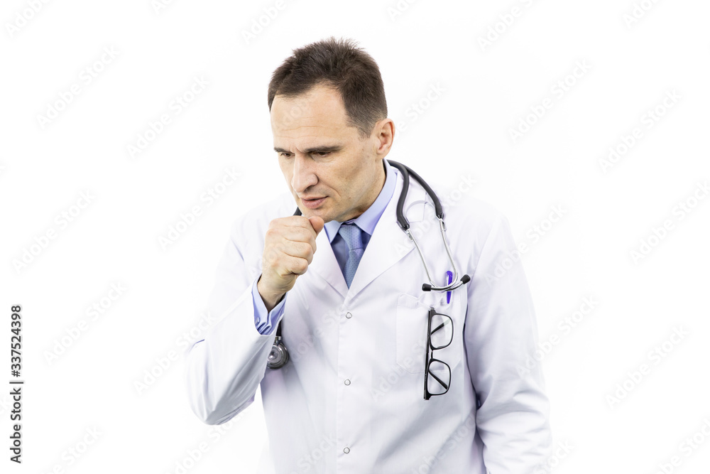 Man coughing into his fist. Viral infection. Symptoms of disease. The doctor got pneumonia. Adult caucasian man in a white coat with a stethoscope over neck on isolated white background. Studio shot Man coughing into his fist. Viral infection. Symptoms of disease. The doctor got pneumonia. Adult caucasian man in a white coat with a stethoscope over neck on isolated white background. Studio shot