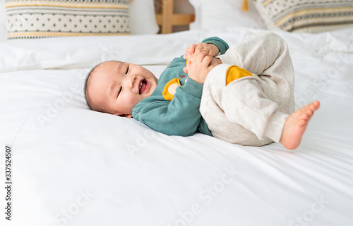 Asian infants crawling and playing on bed
