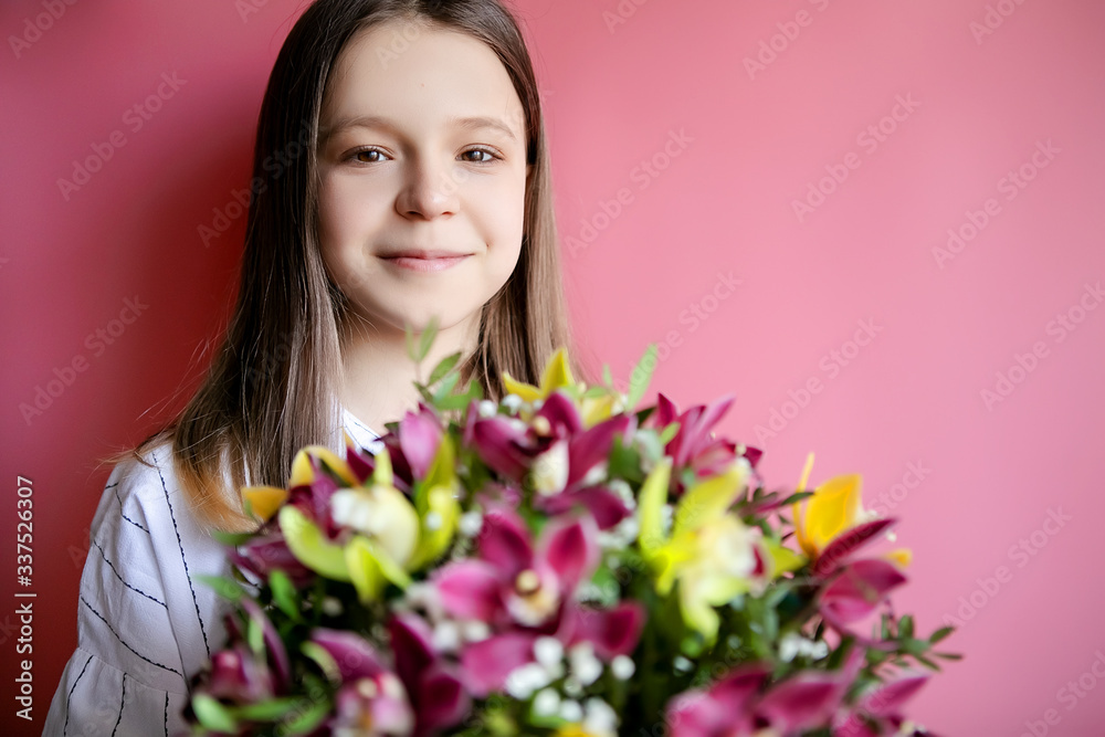 Teenager girl with a bouquet of colorful flowers on a pink background, place for text. Mother's Day Concept Teenager girl with a bouquet of colorful flowers on a pink background, place for text. Mother's Day Concept