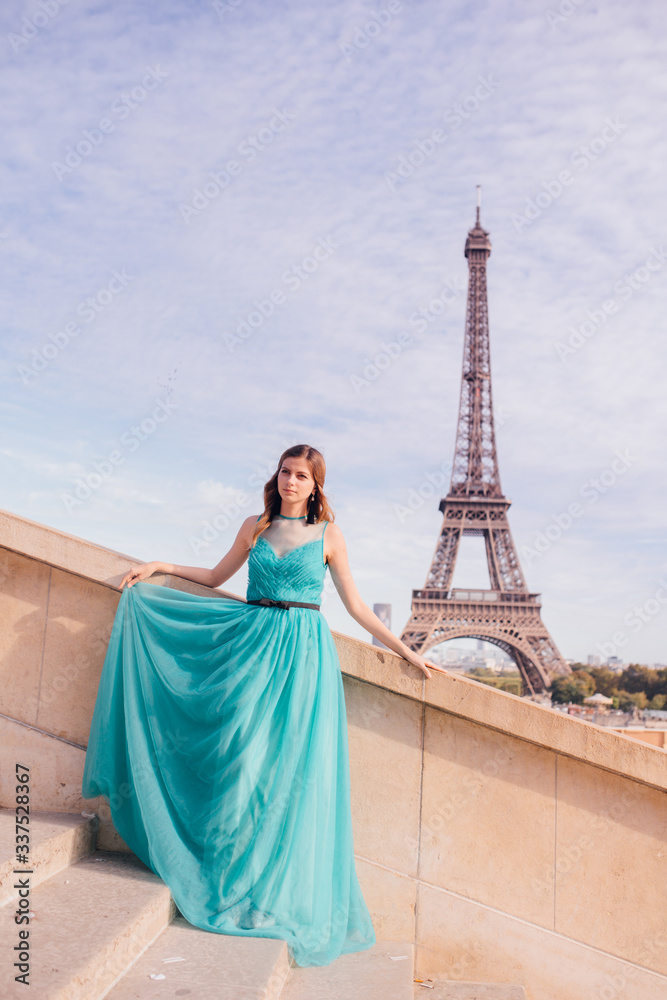 a girl in Paris in a green dress against the backdrop of the Eiffel tower elegant on the Trocadero square in summer a luxurious beautiful figure