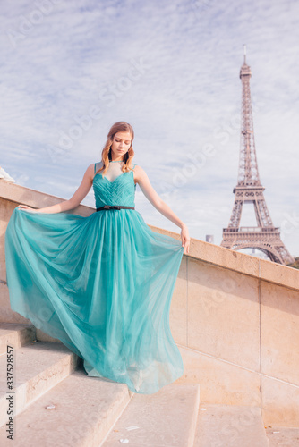 a girl in Paris in a green dress against the backdrop of the Eiffel tower elegant on the Trocadero square in summer a luxurious beautiful figure © Aleksei Zakharov