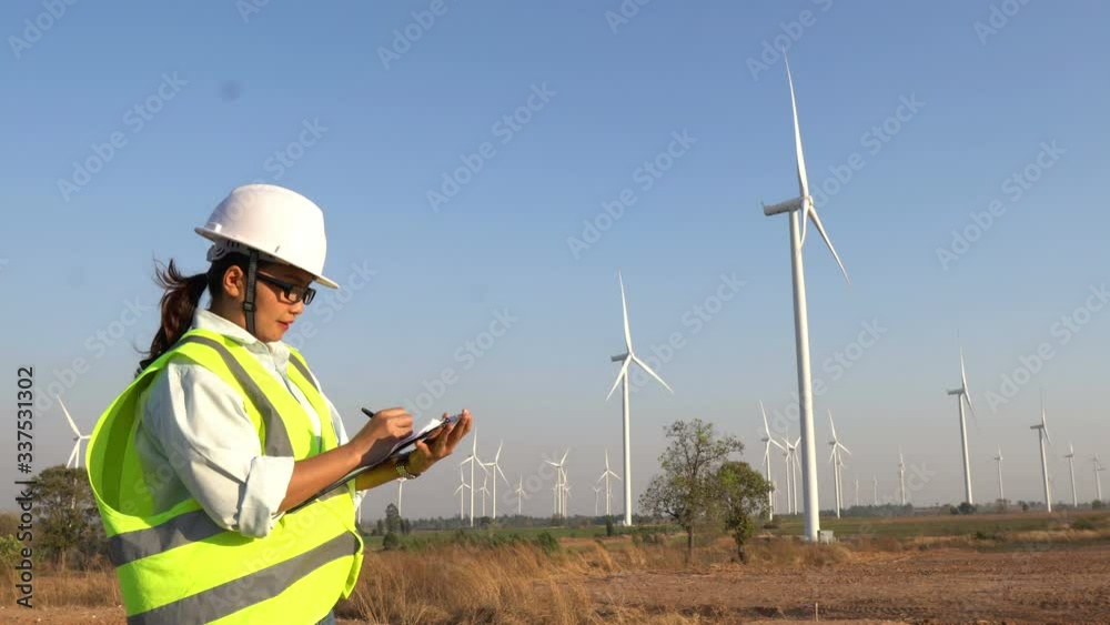 Engineer working and holding the report at wind turbine farm Power Generator Station on mountain,Thailand people
Engineer working and holding the report at wind turbine farm Power Generator Station on mountain,Thailand people