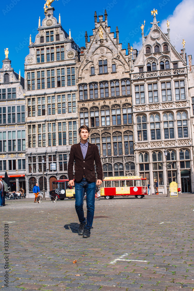 a man on Antwerp square with the city hall and Brabo monument in the Old city, a man on Antwerp square with the city hall and Brabo monument in the Old city,