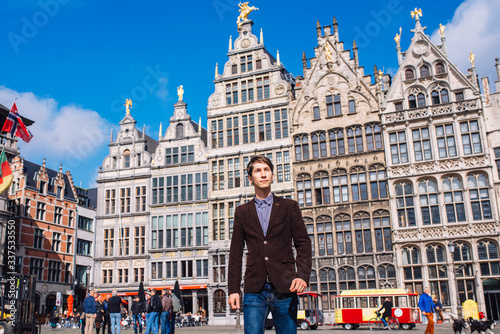 a man on Antwerp square with the city hall and Brabo monument in the Old city,