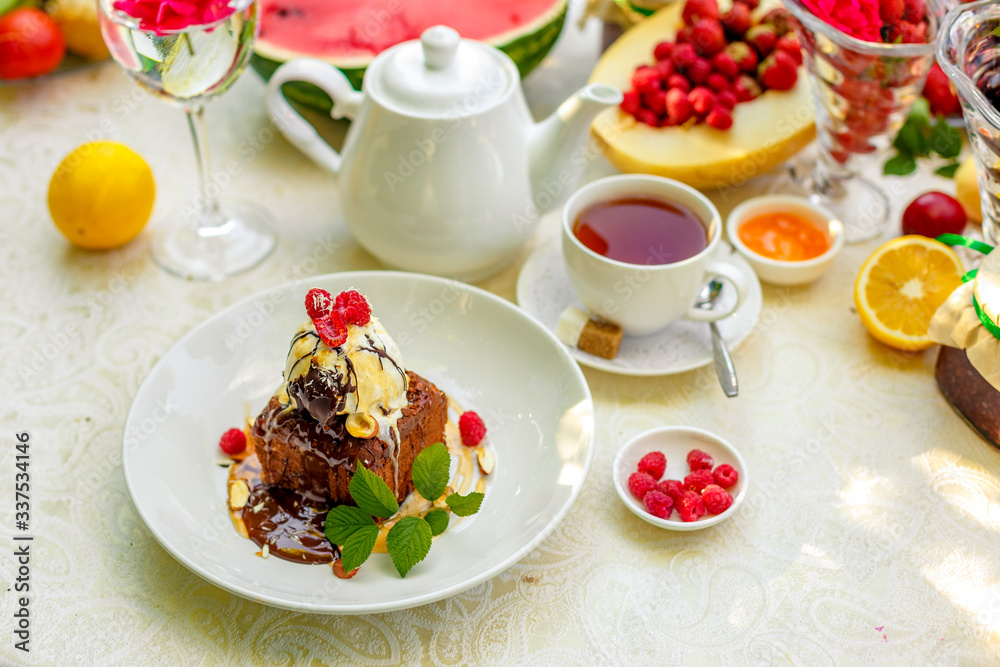 chocolate sponge cake with ice cream and fruit on a served table chocolate sponge cake with ice cream and fruit on a served table