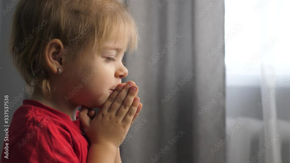 little daughter girl makes a wish prays bedtime religion concept. prayer child indoors praying by bed in lifestyle front of window little daughter girl makes a wish prays bedtime religion concept. prayer child indoors praying by bed in lifestyle front of window