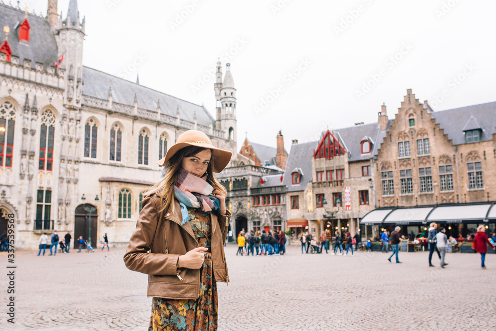 Fototapeta premium a girl looks at a historic building in Bruges