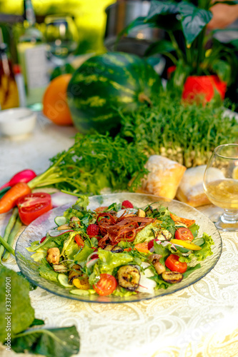 Fresh salad with dried meat, herbs and vegetables served on the table with the ingredients, healthy food