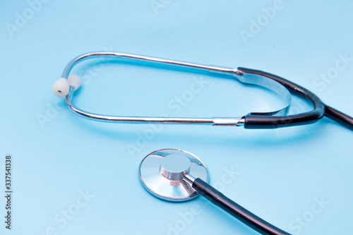 Black Stethoscope isolated on blue background  top view. Medical tool